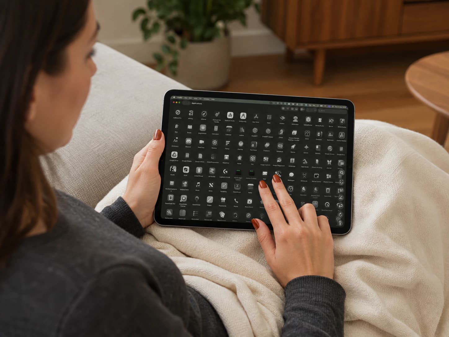 Two fingertips scrolling on an iPad supported in a woman's lap